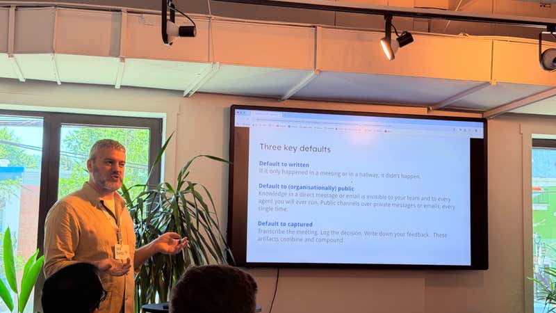 Slide listing three organizational defaults: default to written, default to organisationally public, and default to captured