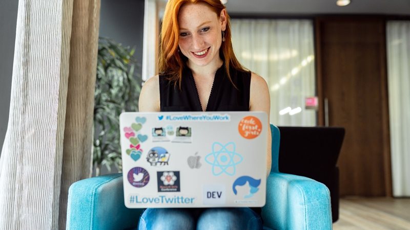 Woman using laptop with React JS sticker on agilitycms.com