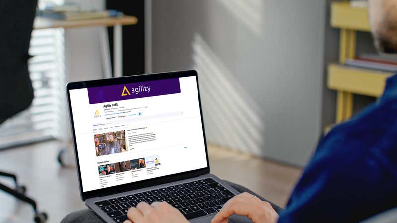User sitting at a laptop looking at Getting Started with Agility CMS The Beginner’s Guide YouTube Series