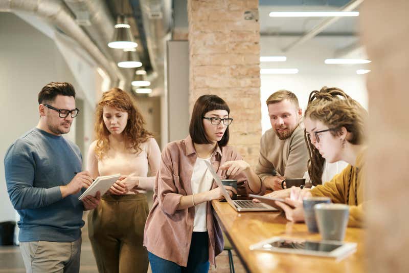 people standing around a desk