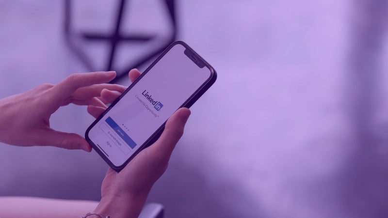 Person logging into LinkedIn with mobile phone on agilitycms.com